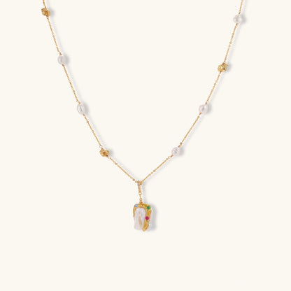 Delicate 18k gold-plated chain with baroque pearls and colorful enamel pendant featuring blue, pink accents on cream background.